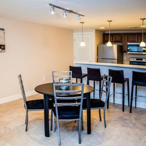 Model unit's dining room and kitchen featuring modern finishes, appliances, and furniture.